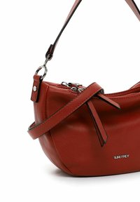 Sarkans ādas plecu somiņa ar noapaļotu formu, aprīkota ar rāvējslēdzēja aizdari, regulējamu siksnu un smalku zīmola logotipa detaļu.