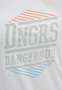 Valge puuvillane T-särk, millel on teemantgraafika, kus on boldis roheline "Dngrs" ja all boldis sinine "DANGEROUS", aktsenteerituna oranži ja siniste joontega.