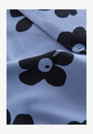 Modro blago z mehko teksturo, ki ima izrazite črne cvetlične vzorce z belimi sredicami, razporejene v razpršen vzorec.