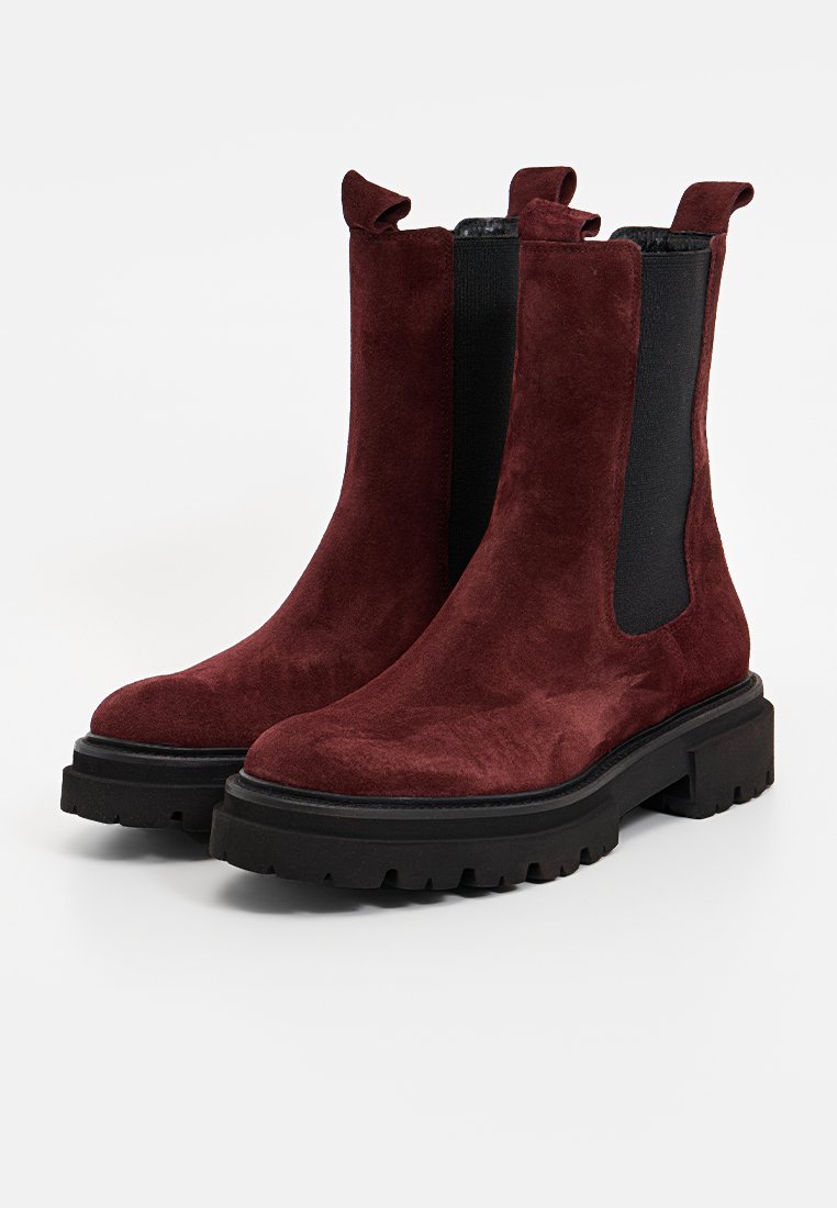 Bordeaux-farbene Wildleder-Stiefeletten mit elastischen Seiteneinsätzen, einer Zuglasche und dicken schwarzen Gummisohlen mit strukturiertem Profil für besseren Halt.