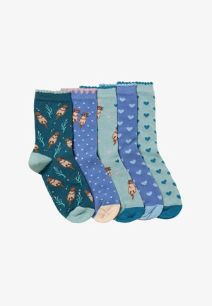 Five pairs of socks featuring varying patterns: otters, polka dots, hearts, and scalloped cuffs, in shades of teal, blue, and pink.