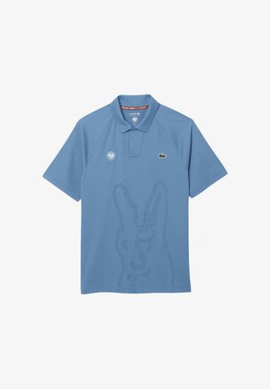 Polo de color azul claro de Lacoste con un diseño sutil de cocodrilo en relieve, logo de Roland Garros en el frente y mangas cortas.