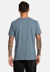 Helles blaues Baumwoll-T-Shirt mit rundem Halsausschnitt und kurzen Ärmeln, mit flachem Saum und dezenten Nähdetails.
