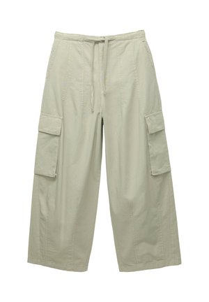 Jasnobeżowe szerokie spodnie typu cargo z ściągaczem w talii i patkami na kieszeniach po bokach.