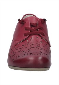 Scarpe stringate in pelle rossa con motivi floreali intagliati, punta arrotondata e superficie testurizzata. Suola piatta.