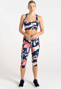 Conjunto de sujetador deportivo y leggings capri en un patrón floral multicolor que incluye azul marino, rosa y verde menta. Hecho de una tela elástica y suave.