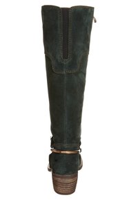 Bota de ante verde oscuro hasta la rodilla con un panel elástico negro, una correa decorativa y un tacón con textura de madera, con costuras en contraste.
