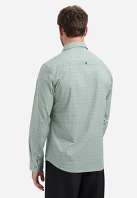 Heren overhemden met lange mouwen in lichtgroen met een geometrisch patroon. Voorzien van een klassieke kraag en knoopdetails aan de achterkant. Gladde stofstructuur.