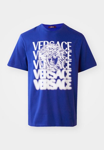 T-shirt en coton bleu avec un grand graphique de Méduse blanc et le texte "VERSACE" répété. Design classique à col rond avec des manches courtes.