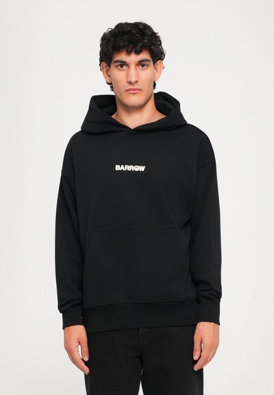 Sudadera con capucha negra de tejido suave, con un bolsillo frontal y un logo en blanco en el pecho. Corte regular con puños y dobladillo acanalados.