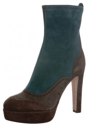 Bottine à talon haut combinant du daim turquoise et brun foncé avec des perforations décoratives et une semelle plateforme.