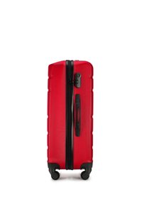 Maleta rígida roja con superficie texturizada, cremallera negra central, asa lateral y cuatro ruedas negras para una movilidad fácil.