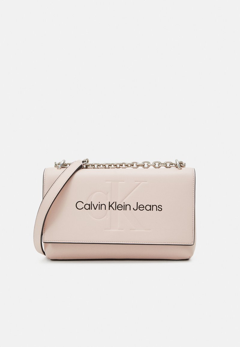 Roze leren handtas met een geperst "CK" logo en "Calvin Klein Jeans" in het zwart gedrukt. Heeft een zilveren kettingband en contrasterende randen.
