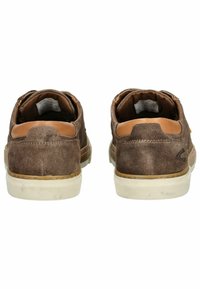 Zapatos de ante marrón con acentos de cuero color marrón claro, suelas de goma blanca y un diseño sencillo. Presentan un logotipo en el talón trasero.