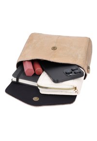 Pochette beige en daim ouverte, contenant un smartphone noir, un portefeuille blanc, un carnet noir et deux rouges à lèvres.