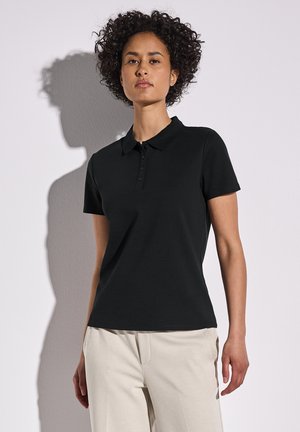 Zwarte polo shirt, korte mouwen, gemaakt van katoen, met een klassieke kraag en een knoopsluiting met drie knopen. Glad textuur, aansluitend ontwerp.