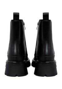 Botas de cuero negro hasta el tobillo con suela gruesa, que presentan una textura suave, cremallera en la parte trasera y paneles laterales elásticos para un ajuste y comodidad óptimos.