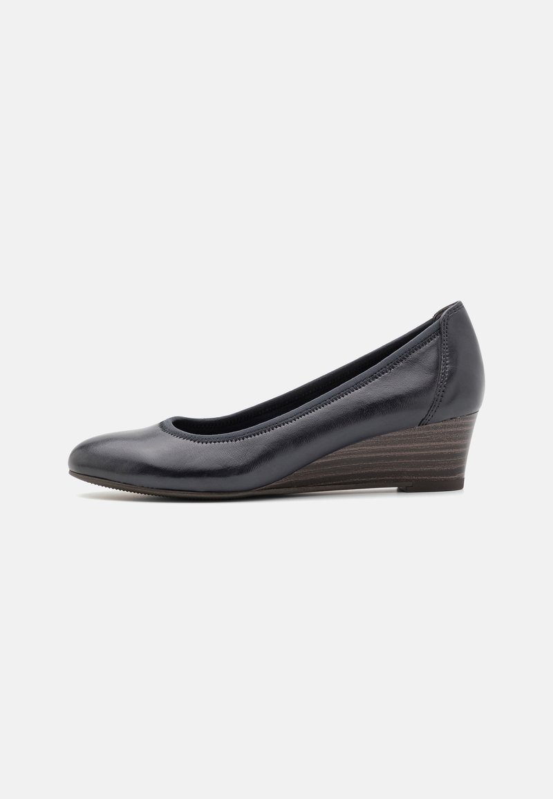 Chaussures à talons compensés en cuir bleu marine avec un bout arrondi, des coutures subtiles et un talon en bois texturé, offrant une apparence lisse et élégante.