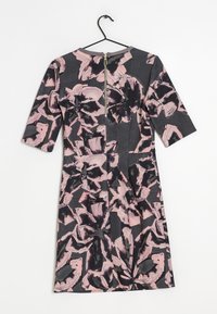 Šaty s krátkými rukávy s tmavým pozadím a abstraktními růžovými a černými květinovými vzory. Zapínání na zip na zadní straně, délka po kolena.