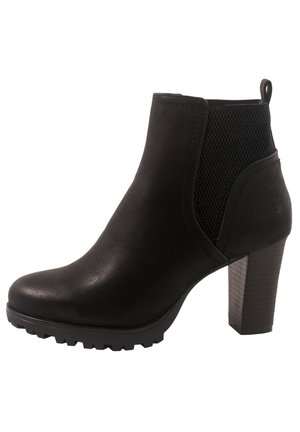 Bottines noires avec une tige en simili cuir texturé, des panneaux latéraux élastiques et un talon épais. Équipées d'une semelle en caoutchouc crantée pour une meilleure adhérence.