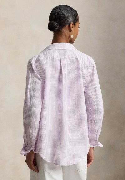 Ριγέ βαμβακερό πουκάμισο λεβάντας με πίσω ποδιά, μακριά μανίκια, κουμπωτά μανσέτες και καμπυλωτή ραφή. Ορατή υφή και ελαφριά ζάρωση.