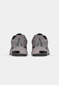 Grå mesh- och syntetiska löparskor med svarta detaljer, utrustade med en dämpad sula och synliga luftfickor i hälen.