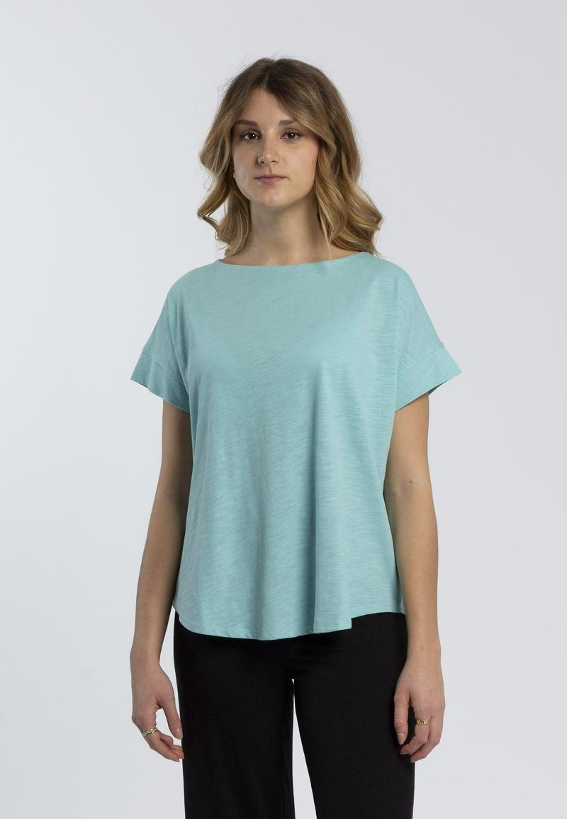 Top corto maniche corte di un verde turchese chiaro con scollo rotondo, realizzato in tessuto morbido e leggero, caratterizzato da una vestibilità comoda e senza motivi visibili.