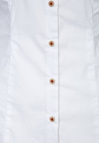 Biała koszula zapinana na guziki, wykonana z teksturowanej tkaniny, z okrągłymi, beżowymi guzikami ozdobionymi małymi czerwonymi serduszkami wzdłuż środkowej listwy.