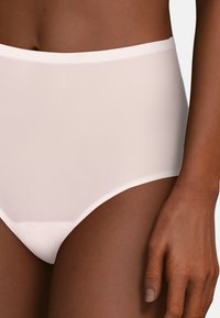Mutandina da bikini bianca a vita alta realizzata in tessuto liscio e elasticizzato. Presenta un design senza cuciture e una vita elastica aderente per il massimo del comfort.