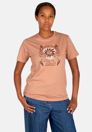Hellbraunes Baumwoll-T-Shirt mit einem zentralen Sonnenmotiv in Dunkelbraun und Gelb. Kurze Ärmel und Rundhals. Jeans mit lockerer Passform.