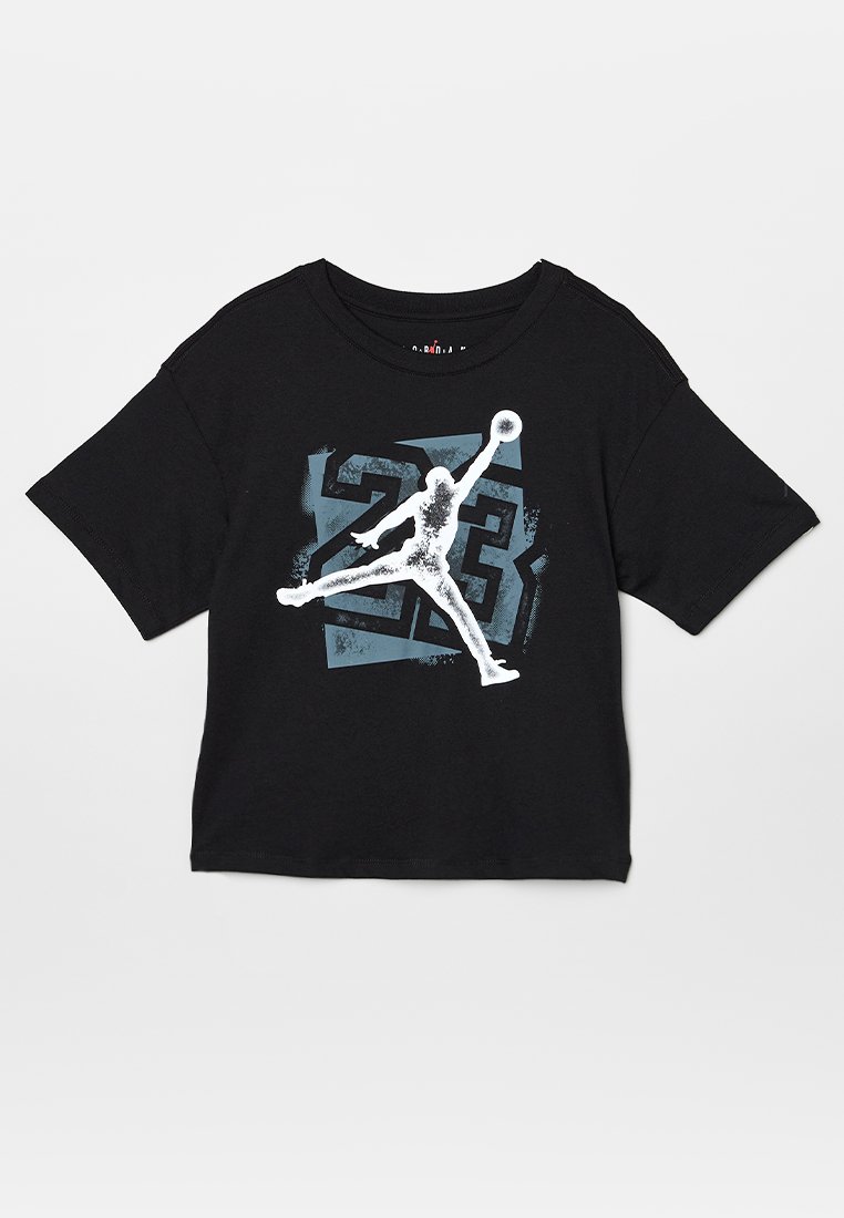 T-shirt in cotone nero con una grande grafica bianca di una figura in salto e il numero "23" in blu dietro di essa. Maniche corte e collo rotondo.