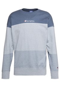 Světle a tmavě šedá mikina se horizontálním pruhovaným designem, kulatým výstřihem a centrálním logem Champion na hrudi. Bavlněný materiál.