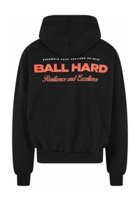 Crna dukserica s prostranom kapom, elastičnim manžetama i skraćenim rubom. Na leđima se nalazi natpis "BALL HARD" i "Resilience and Excellence" u podebljanoj narančastoj boji.