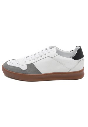 Weißes Leder-Sneaker mit grauen Wildlederakzenten, perforierter Zehenpartie und schwarzer Lederferse. Eine braune Gummisohle und flache Schnürsenkel runden das Design ab.