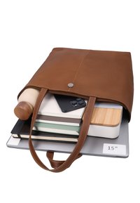 Braune Ledertasche (Tote) mit einem Laptop, einer Wasserflasche, einem Smartphone, Notizbüchern und einem Lebensmittelbehälter mit Holzdeckel.