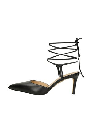 Scarpa nera in pelle con tacco alto, punta affusolata, lati aperti e design incrociato con lacci alla caviglia. Presenta un sottile tacco a stiletto.