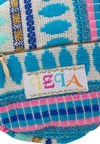 Astuccio di stoffa ricamato colorato con motivi geometrici in blu, rosa e turchese. Include un'etichetta decorativa con testo multicolore.