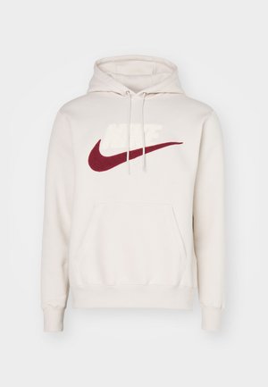 Creamfarbene Hoodie aus Baumwollmischung mit großem rotem Nike-Logo, Fronttasche und Kordelzugkapuze. Weicher Stoff mit gerippten Bündchen.