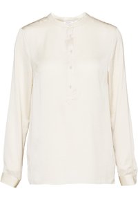 Blusa a maniche lunghe crema con scollo rotondo e una corta patta di bottoni con cinque bottoni lungo il centro davanti.