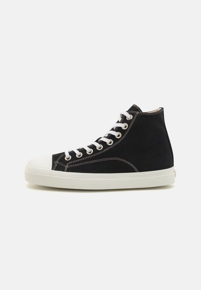 Baskets montantes noires en toile avec semelle et capuchon en caoutchouc blancs. Elles présentent des lacets blancs et des détails de couture contrastants.