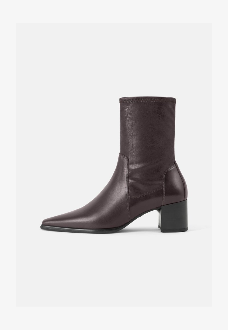 Botins burgundy feitos de couro liso com biqueira pontiaguda e salto quadrado. O cano é elegante e ajustado, indo até a metade da panturrilha.