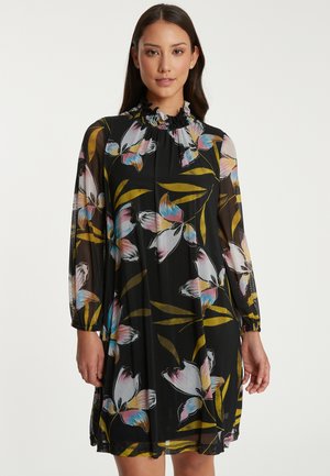 Bloemendress met een zwarte sheer stof, lange pofmouwen, een ruches kraag en kleurrijke bloemmotieven in roze en blauwe tinten.