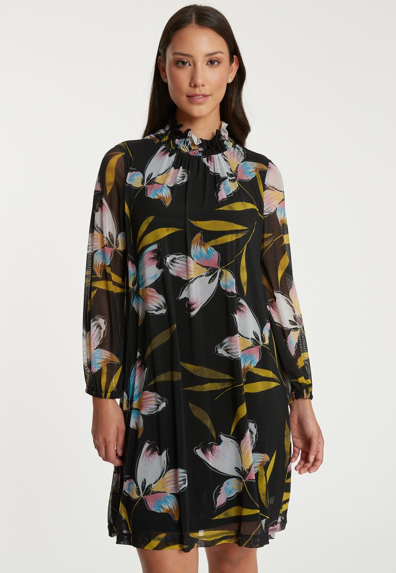 Blumenkleid aus einem schwarzen, durchsichtigen Stoff, mit langen Puffärmeln, einem rüschigen Kragen und bunten Blumenmustern in Rosa- und Blautönen.