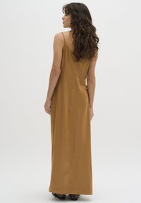 Satin, langes, braunes Kleid mit dünnen Trägern und geradem Schnitt. Glatte Textur und minimale Details für ein elegantes Erscheinungsbild.
