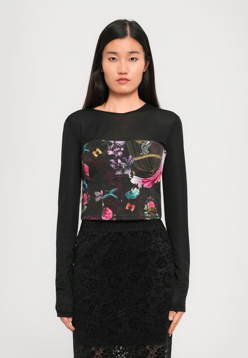 Black long-sleeve top with a floral design in vibrant colors, paired with a black lace skirt featuring a floral pattern and an elastic waistband.