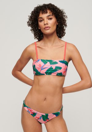 Set bikini con base rosa, stampa di foglie tropicali e fiori. Il top ha spalline regolabili; il fondo presenta dettagli hardware laterali.