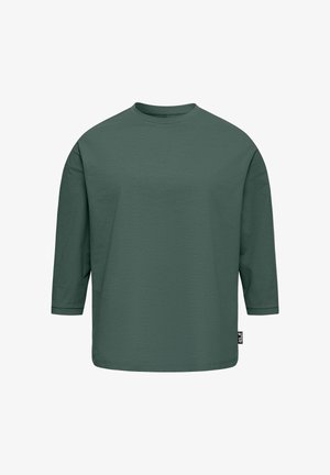 Donkergroene, lange mouwen, shirt met ronde hals en een losse pasvorm, met een klein zwart label aan de rechteronderkant.