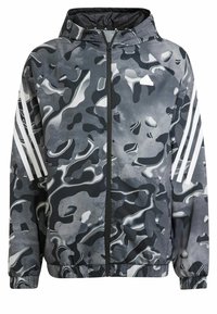 Camouflage jacket in black, gray, and white; features a zip front, hood, elastic cuffs, and three white stripes on the sleeves.