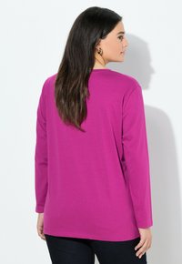 Langsleeve top in felroze met een relaxte pasvorm, gemaakt van zacht materiaal. Heeft een ronde halslijn en een gladde textuur.