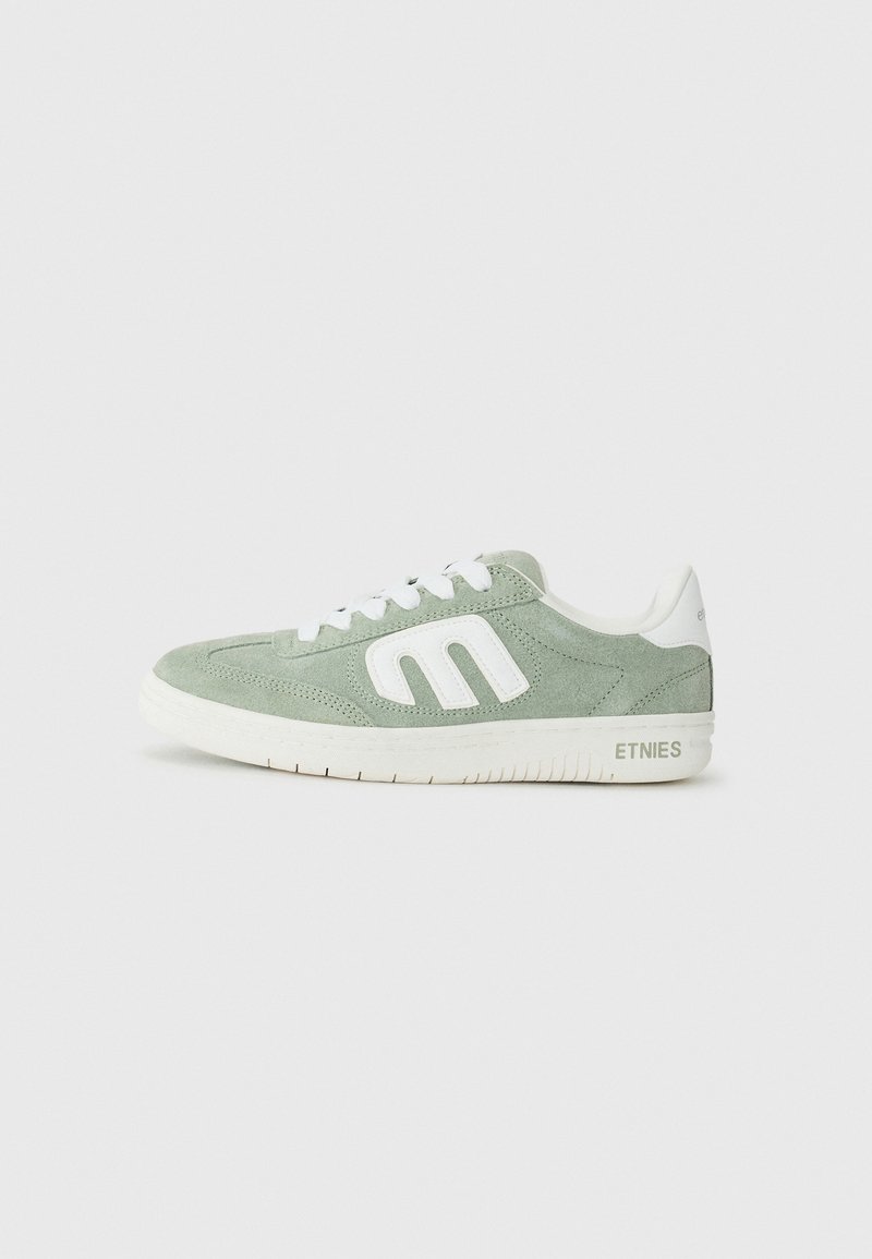 Roheline sametist sneakers valgete aktsentidega, ümarate varvastega, nööbitava esitusega ning logodetailiga külje ja kandmise peal.